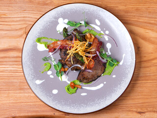 Warm liver salad with bacon, mushrooms, potatoes chips and asparagus.