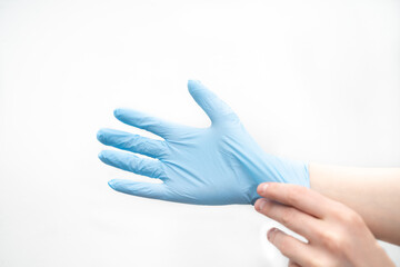 putting on a disposable latex glove on a white background