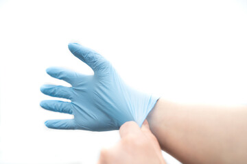 putting on a disposable latex glove on a white background