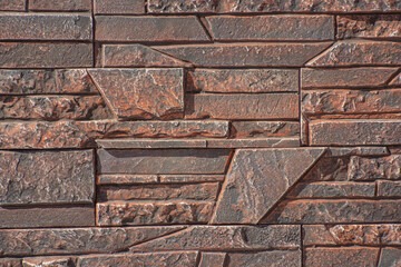 Texture of decorative stone for finishing the facade of a house with a brown tint