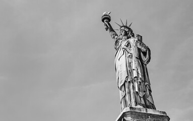 The Statue of Liberty, outdoor statue on a clear blue sky background on Liberty Island, New York, USA with copy space, empty space for text in black and white