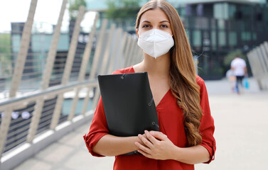 Unemployed serious woman with KN95 FFP2 protective mask looking worried at camera