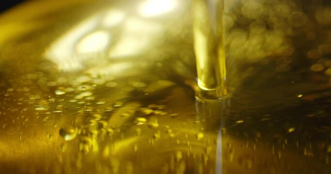 Stream olive oil flows with air bubbles.
