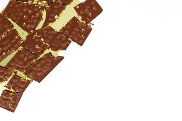 Chocolate pieces with nuts in the shape of a frame, isolated, broken on a white background.
