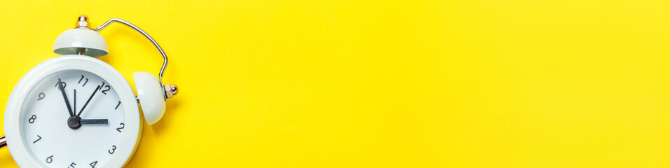 Simply minimal design ringing twin bell classic alarm clock Isolated on yellow background. Rest...