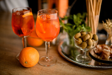 Close-up of two beautiful glasses of cold bright orange drink stand on the table