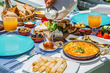 Concept promotional morning breakfast in the hotel, tasty Egg Benedict,Turkish and French Breakfast, tea and orange juice. near swimming pool in the garden