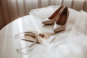 Wedding details. Diadem with diamonds, rings of the bride and groom, veil, shoes, invitation,...