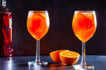 Aperol spritz cocktail on dark background. Two glasses of aperol spritz with orange slised. Summer cocktail in glass. Copy space