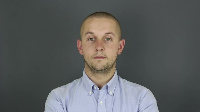 A funny, cute guy asks for a callback and makes a hand gesture. Portrait of a young guy, he makes a hand gesture next to his ear asking for a callback.