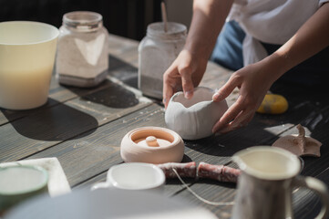 Fototapeta na wymiar Production process of pottery. Application of glaze brush on ceramic ware.