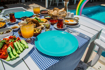 Concept promotional morning breakfast in the hotel, tasty Egg Benedict,Turkish and French Breakfast, tea and orange juice. near swimming pool