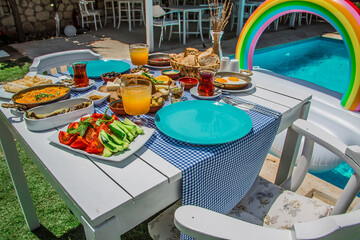 Concept promotional morning breakfast in the hotel, tasty Egg Benedict,Turkish and French Breakfast, tea and orange juice. near swimming pool