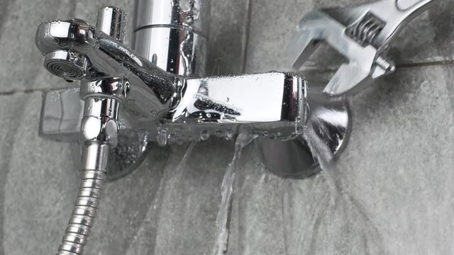 Plumber Fixing a water leaking tap Faucet by Adjustable wrench , DIY job hous keep work fix leak repair.