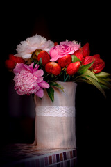Bouquet of peonies with strawberries. Strawberry bouquet in a vase of natural linen