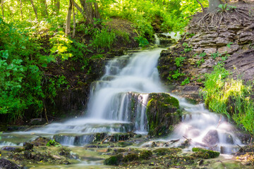 Fototapeta na wymiar Small creek waterfall in the forest