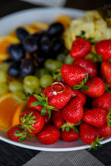 The wedding ring lies on a red ripe strawberry. Summer delicious berries