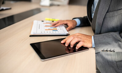 Closeup shot of a businessman analyzing statistics on a digital tablet in an office