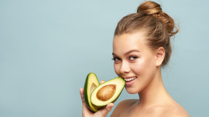 Beautiful young woman with fresh avocado on light background