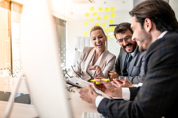 Businessmen and businesswoman looking and laughing