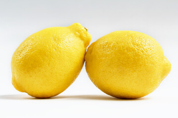 Two whole lemons isolated on a white background.