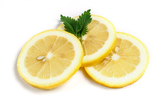 Three slices of fresh lemon and a leaf of mint isolated on a white background.
