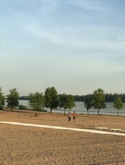 Obraz premium landscape beach near the river along the path in the distance pass people