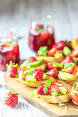 Fresh berry drink on a summer day and bruschetta with strawberries and avocado salsa. Delicious snacks, balanced nutrition.