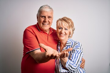 Senior beautiful couple standing together over isolated white background Smiling with hands palms together receiving or giving gesture. Hold and protection