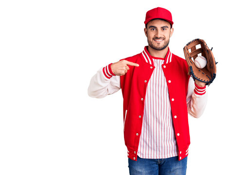 Young handsome man holding baseball gloves pointing finger to one self smiling happy and proud