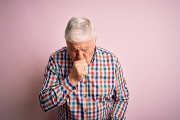 Senior handsome hoary man wearing casual colorful shirt over isolated pink background feeling...