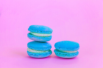 Sweet almond colorful unicorn blue macaron or macaroon dessert cake isolated on trendy pink pastel background. French sweet cookie. Minimal food bakery concept Copy space