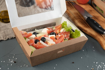 Eco packaging - Greek salad in a craft box for delivery. Vegan food.