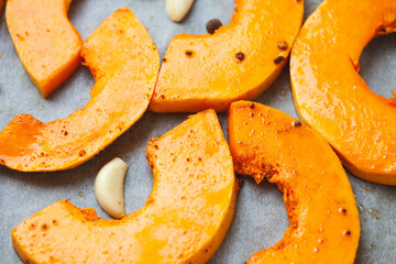 Bright slices of pumpkin prepared for baking in the oven. Soft focus.