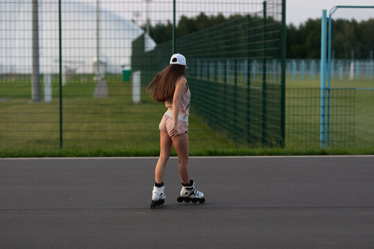 Girl roller skating in the park. Sports girl roller skating.