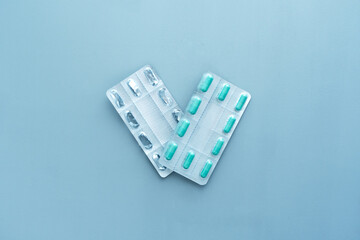 Empty vs full blisters from tablets on a blue background. Medical, environmental concept. Health therapy. Pandemic, epidemic, vaccination.