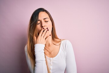 Young beautiful blonde woman with blue eyes wearing white t-shirt over pink background bored...