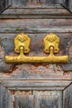 old wooden door with chipped paint and vintage gold door knocker