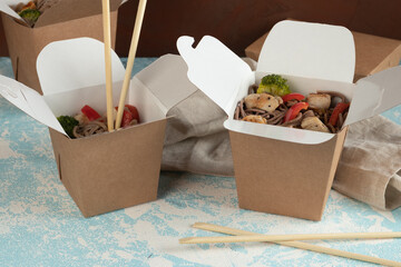 Eco packaging - noodles with vegetables, chicken and meat in craft packaging for the delivery service. Fast food.