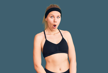 Fototapeta premium Young beautiful blonde woman wearing sportswear afraid and shocked with surprise expression, fear and excited face.