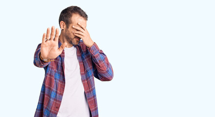 Young handsome man wearing casual clothes covering eyes with hands and doing stop gesture with sad and fear expression. embarrassed and negative concept.