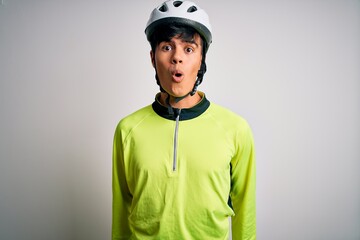 Young handsome cyclist man wearing security bike helmet over isolated white background afraid and shocked with surprise expression, fear and excited face.