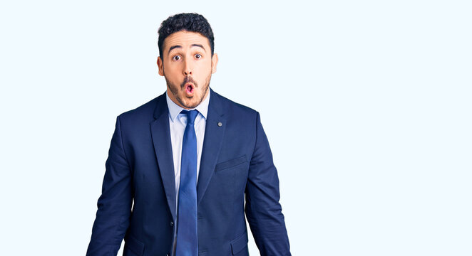 Young hispanic man wearing business clothes scared and amazed with open mouth for surprise, disbelief face