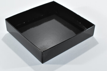 Czarne tekturowe pudełko na białym tle. - obrazy, fototapety, plakaty