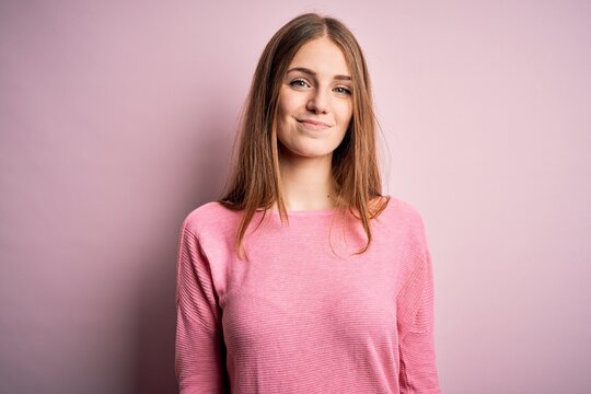 Young beautiful redhead woman wearing casual sweater over isolated pink background looking sleepy and tired, exhausted for fatigue and hangover, lazy eyes in the morning.