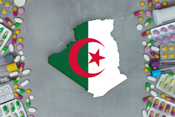 The Algeria State began research for treatment and medicine to combat the pandemic outbreak disease coronavirus. Medicine, pills, needles, syringes and Algeria map and flag on gray background.