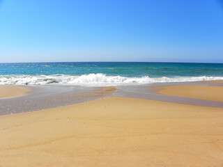 Fototapeta na wymiar Atlantic Ocean, Santa Cruz Beach, Portugal. Turquoise ocean and yellow sand. Travel, vacation, vacation, paradise, relaxation.