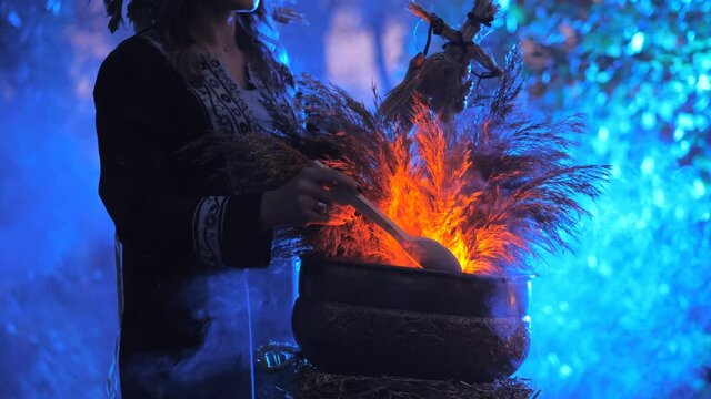 A forest witch brews a potion holding a Voodoo doll