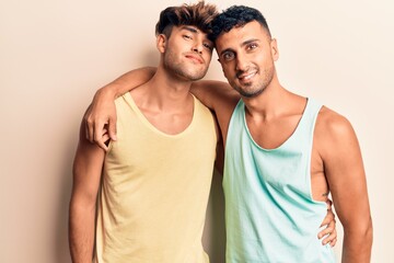 Fototapeta premium Young couple of men wearing summer clothes smiling happy. Standing with smile on face hugging over isolated white background