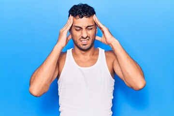 Young hispanic man wearing casual clothes with hand on head, headache because stress. suffering...